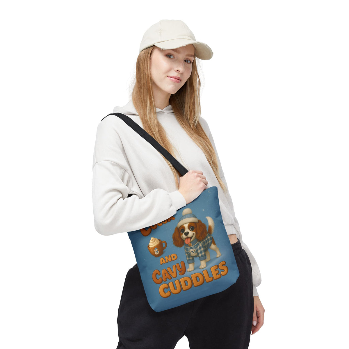 Woman in a cap carrying the Blenheim Cavalier Cocoa and Cavy Cuddles tote over her shoulder, front view